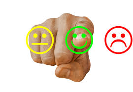 Image is of someone pressing a happy emoji that is beside an indifferent one and a angry one.
